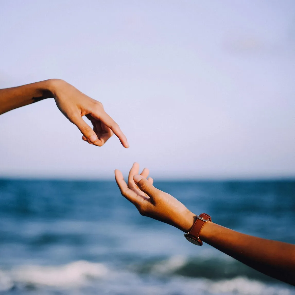 Two hands reaching toward each other